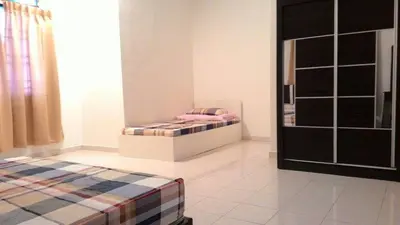 a bedroom with two beds and a door to a room at J&P Homestays House 1 in Kampar