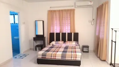 a bedroom with a bed and a dresser in it at J&P Homestays House 1 in Kampar