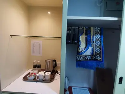 two pictures of a kitchen with a counter and a refrigerator at Hotel Seri Malaysia Kulim in Kulim