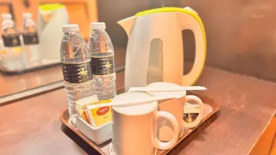 a tray with cups and water bottles on a table at Hotel Seri Malaysia Kepala Batas in Kepala Batas