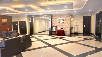 a lobby with chairs and a table in a building at Hotel Seri Malaysia Kepala Batas in Kepala Batas