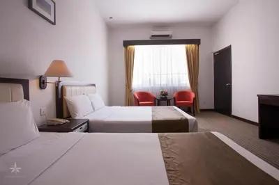 a hotel room with two beds and a window at Hotel Seri Malaysia Kepala Batas in Kepala Batas