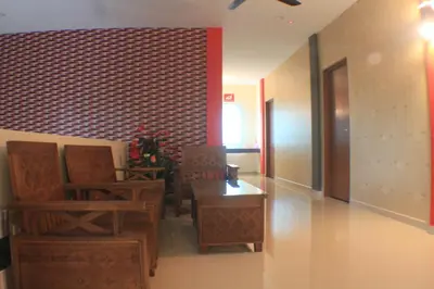 a lobby with chairs and a table and a brick wall at Pz Hotel in Kuala Kangsar