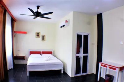 a bedroom with a bed and a ceiling fan at Pz Hotel in Kuala Kangsar