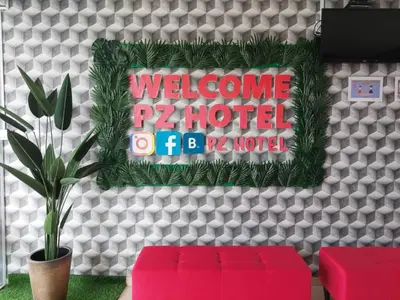 a welcome to a hotel sign on a wall with two red stools at Pz Hotel in Kuala Kangsar