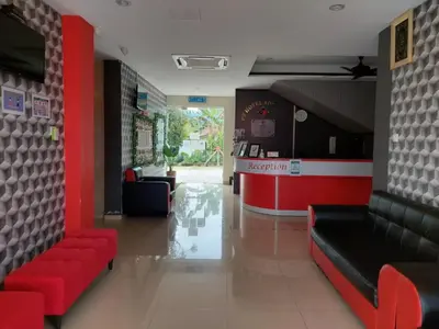 a lobby with red and black furniture and a bar at Pz Hotel in Kuala Kangsar