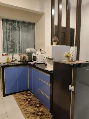 a kitchen with blue cabinets and a microwave at Leezahomestay in Bayan Lepas