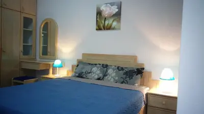 a bedroom with a blue bed with two lamps at Pinang Beach Apartment @ Bayu Emas in Batu Ferringhi
