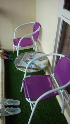two purple chairs and a table in front of a window at Pinang Beach Apartment @ Bayu Emas in Batu Ferringhi