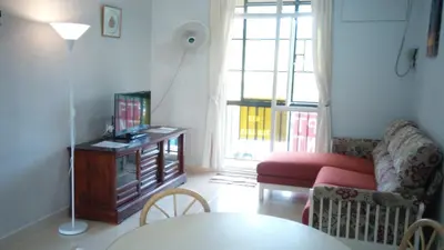 a living room with a couch and a tv at Pinang Beach Apartment @ Bayu Emas in Batu Ferringhi