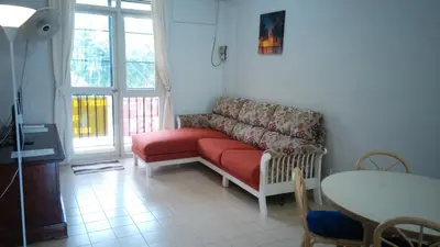 a living room with a red couch and a table at Pinang Beach Apartment @ Bayu Emas in Batu Ferringhi