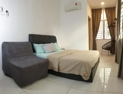 a bedroom with a bed and a chair at De Nest Holiday home in Bayan Lepas