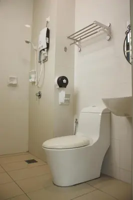 a bathroom with a toilet and a phone on the wall at De Nest Holiday home in Bayan Lepas