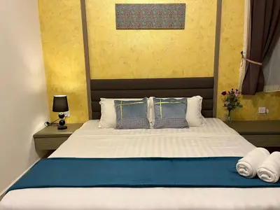 a bedroom with a large bed with blue and white sheets at Sekata Apartment in Cameron Highlands
