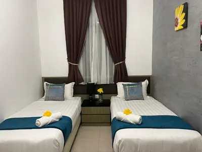 two twin beds in a room with a window at Sekata Apartment in Cameron Highlands