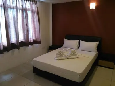 a bedroom with a bed with white sheets and a window at T-Hotel Ipoh in Ipoh