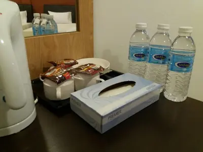 a table with bottles of water and snacks on it at T-Hotel Ipoh in Ipoh