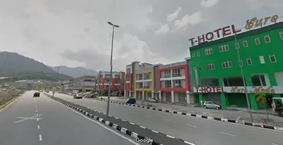 a city street with buildings and cars on a road at T-Hotel Ipoh in Ipoh