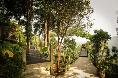 a path with trees and a fence next to the water at MaliHom Private Estate in Balik Pulau