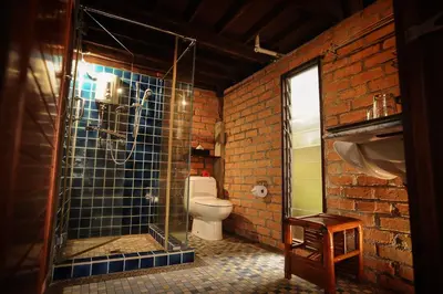 a bathroom with a toilet and a glass shower at MaliHom Private Estate in Balik Pulau