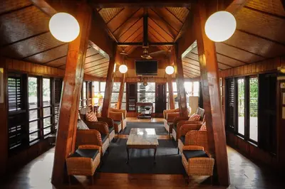 a lobby with chairs and a table and a tv at MaliHom Private Estate in Balik Pulau
