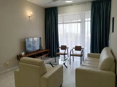 a living room with a couch and a table and a television at City Tropical Home I in George Town