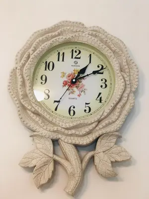 a clock on a wall with leaves on it at Homestay Cahaya 1 Seri Iskandar in Seri Iskandar