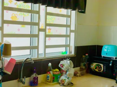 a kitchen counter with a sink and two windows at Homestay Cahaya 1 Seri Iskandar in Seri Iskandar