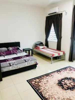 a bedroom with two beds and two rugs on the floor at Homestay Cahaya 1 Seri Iskandar in Seri Iskandar