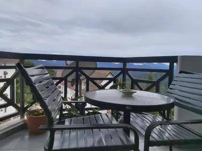 a table and chairs on a balcony with a table at FH Comfy Home in Bukit Fraser
