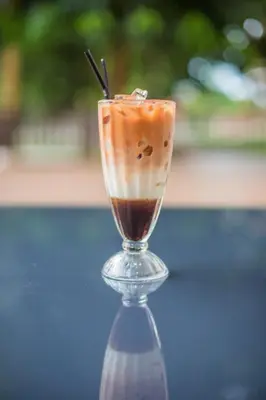 a drink in a glass sitting on a table at Sayong Resort in Kuala Kangsar