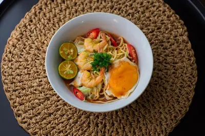 a bowl of food with shrimp and vegetables on a table at Sayong Resort in Kuala Kangsar