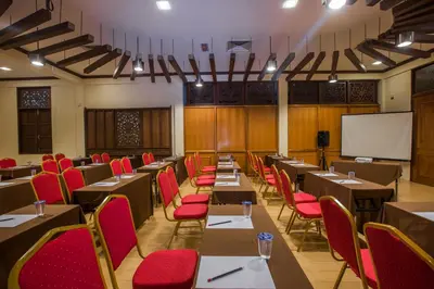 a conference room with tables and chairs and a whiteboard at Sayong Resort in Kuala Kangsar
