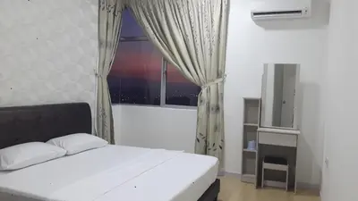 a bedroom with a white bed and a window at Taiping Homestay in Taiping
