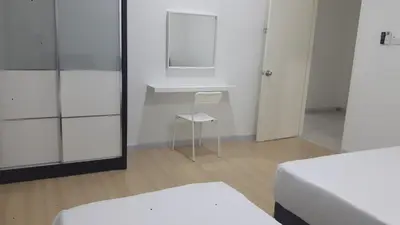 a room with two beds and a chair and a mirror at Taiping Homestay in Taiping