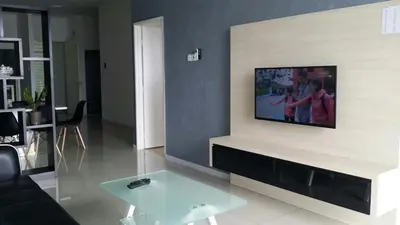 a living room with a tv on a wall at Taiping Homestay in Taiping