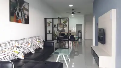 a living room with a black couch and a glass table at Taiping Homestay in Taiping