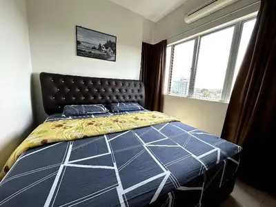 a bedroom with a bed with a blue comforter and two windows at Sekinchan SeaBreeze Homestay \u9002\u8015\u5e84\u6d77\u98ce\u5439\u6c11\u5bbf in Sekincan