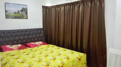 a bedroom with a bed with a yellow blanket at Sekinchan SeaBreeze Homestay \u9002\u8015\u5e84\u6d77\u98ce\u5439\u6c11\u5bbf in Sekincan