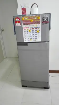 a refrigerator with a calendar on the top of it at Sekinchan SeaBreeze Homestay \u9002\u8015\u5e84\u6d77\u98ce\u5439\u6c11\u5bbf in Sekincan