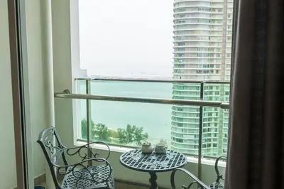 a table and a chair in a room with a window at Sky Suites in George Town