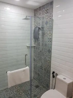 a bathroom with a glass shower with a toilet at Little Kampung Studio in Teluk Intan