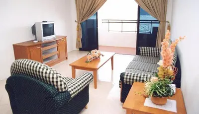 a living room with two chairs and a tv at Marina Cove Resort in Lumut