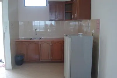 a kitchen with wooden cabinets and a refrigerator at Marina Cove Resort in Lumut