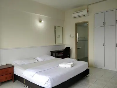a bedroom with a bed with a desk and a mirror at Lumut Valley Condominium in Lumut