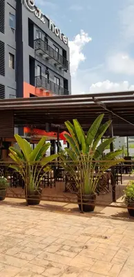 a hotel with potted plants in front of a building at Cute Hotel & Dorms Ipoh in Ipoh