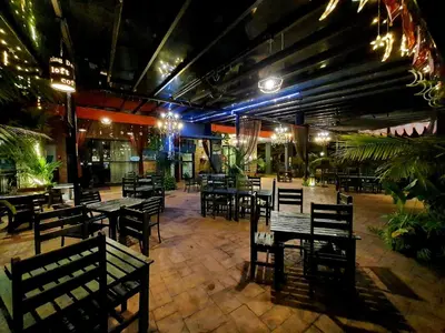 an empty restaurant with tables and chairs and lights at Cute Hotel & Dorms Ipoh in Ipoh