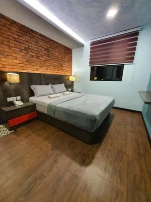 a bedroom with a large bed and a window at Cute Hotel & Dorms Ipoh in Ipoh