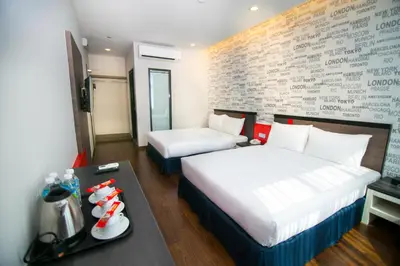 a hotel room with two beds and a table at INDRA HOTEL - BOUTIQUE SUITES in Ipoh