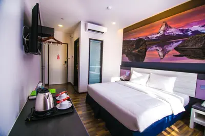 a hotel room with a bed and a tv at INDRA HOTEL - BOUTIQUE SUITES in Ipoh